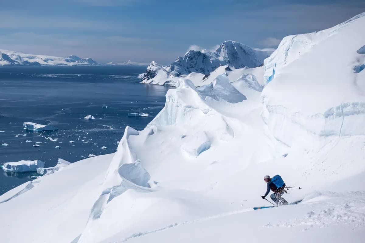 Two people playing in the snow on a ski slope